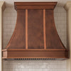 Faceted Curved Custom Copper Range Hood with Vertical Straps and Contrasting Trim