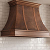 Faceted Curved Custom Copper Range Hood with Vertical Straps and Contrasting Trim