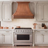 Traditional kitchen with handcrafted custom copper curve shape range hood and hammered apron detail